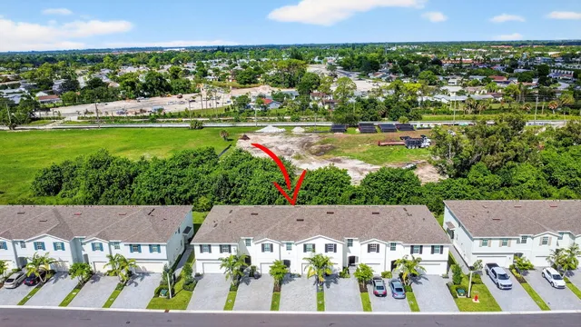 an aerial view of a city with lots of residential buildings ocean and mountain view in back