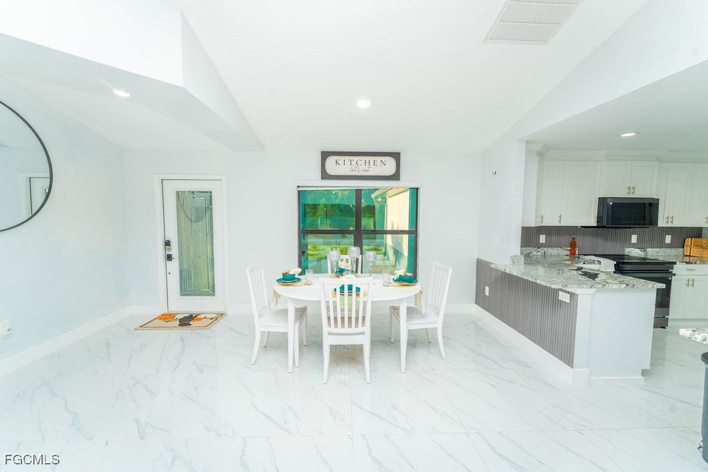3613 39th Street Southwest Lehigh Acres, FL 33976 - Photo 18 of 46 a dining room with a window and chairs