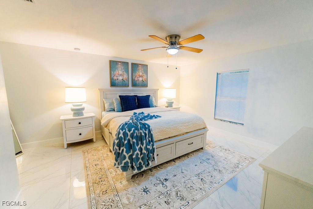 3613 39th Street Southwest Lehigh Acres, FL 33976 - Photo 23 of 46 a bedroom with a bed a chandelier and a rug