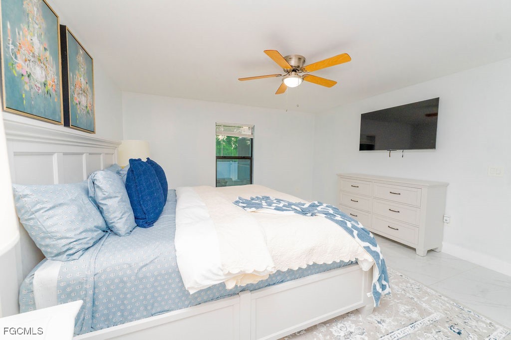 3613 39th Street Southwest Lehigh Acres, FL 33976 - Photo 25 of 46 a bedroom with a bed a flat screen tv and dresser
