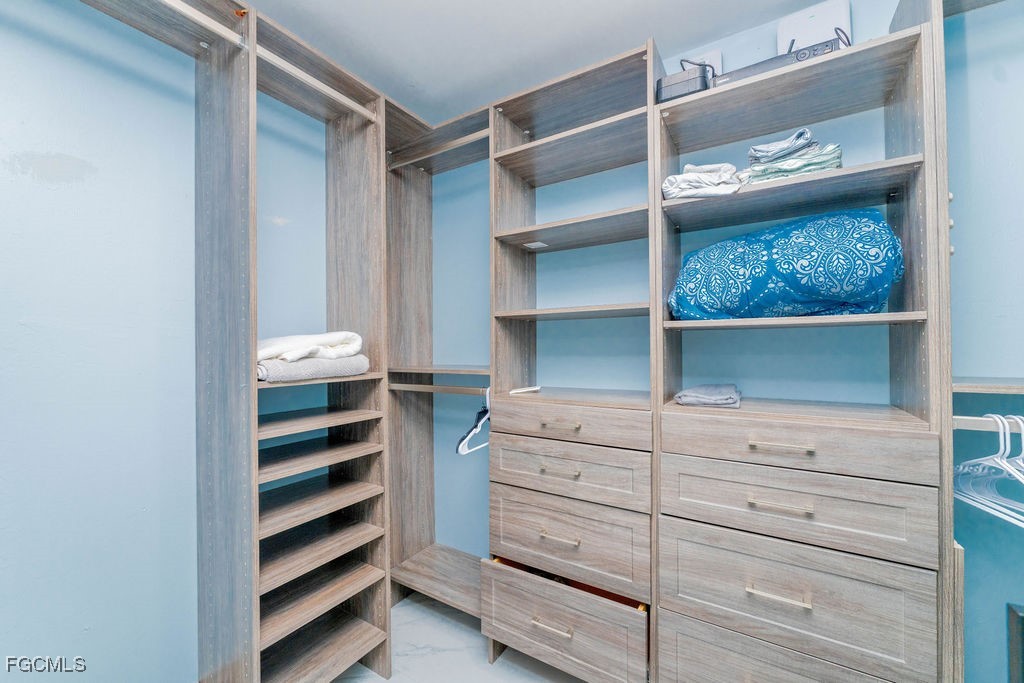 3613 39th Street Southwest Lehigh Acres, FL 33976 - Photo 26 of 46 a view of walk in closet with clothes and shoes