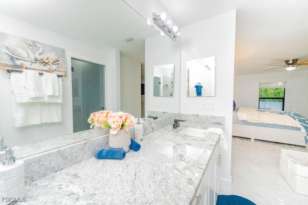 3613 39th Street Southwest Lehigh Acres, FL 33976 - Photo 29 of 46 a bathroom with a granite countertop sink a large mirror and a shower