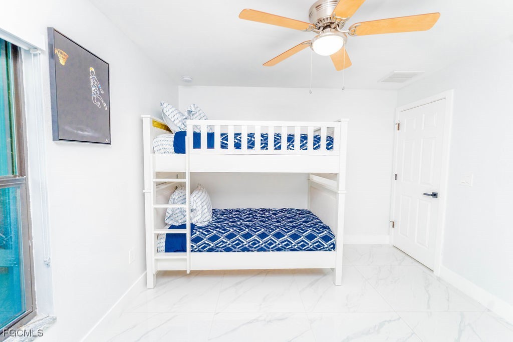 3613 39th Street Southwest Lehigh Acres, FL 33976 - Photo 33 of 46 a room with a bed and a chandelier