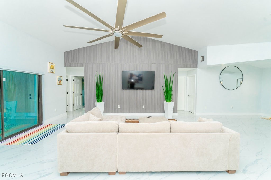 3613 39th Street Southwest Lehigh Acres, FL 33976 - Photo 4 of 46 a living room with a bed mirror and a chandelier