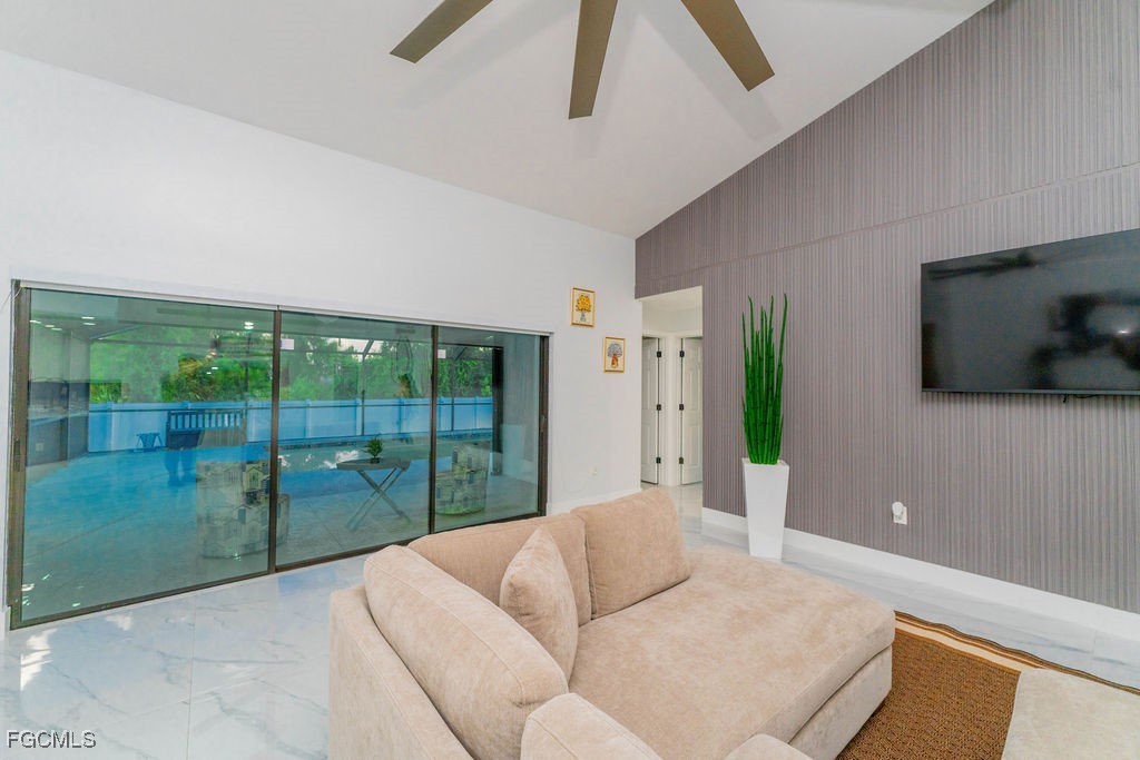3613 39th Street Southwest Lehigh Acres, FL 33976 - Photo 10 of 46 a living room with furniture tv and a floor to ceiling window