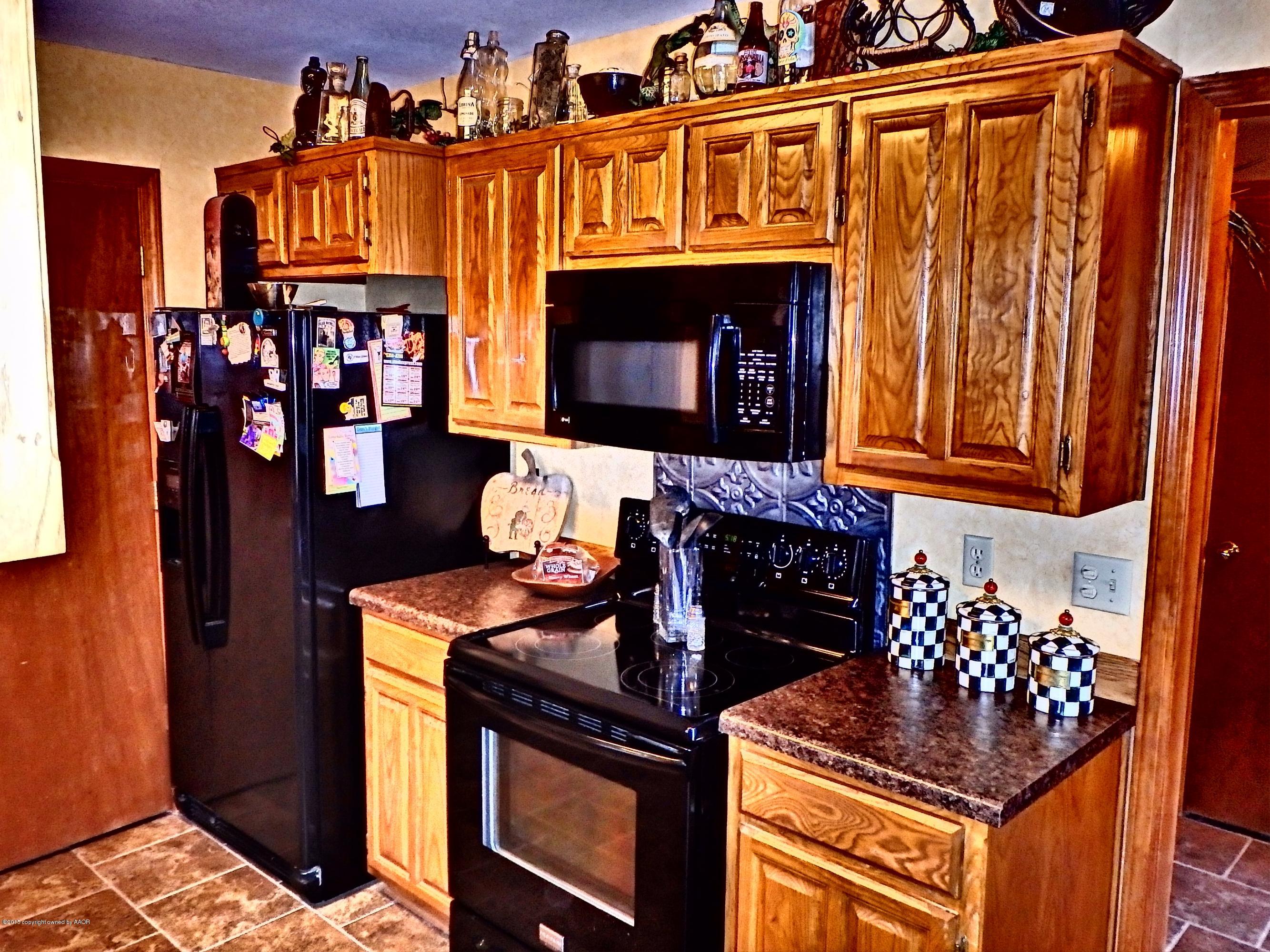 4203 Rincon Avenue Amarillo, TX 79110 - Photo 12 of 39 a kitchen with stainless steel appliances granite countertop a stove and cabinets