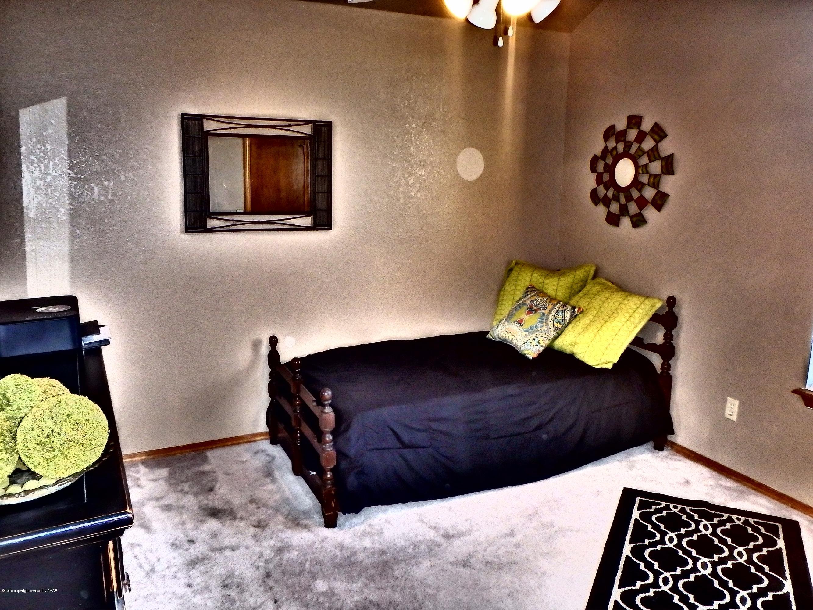 4203 Rincon Avenue Amarillo, TX 79110 - Photo 18 of 39 a bedroom with a bed and painting on the wall