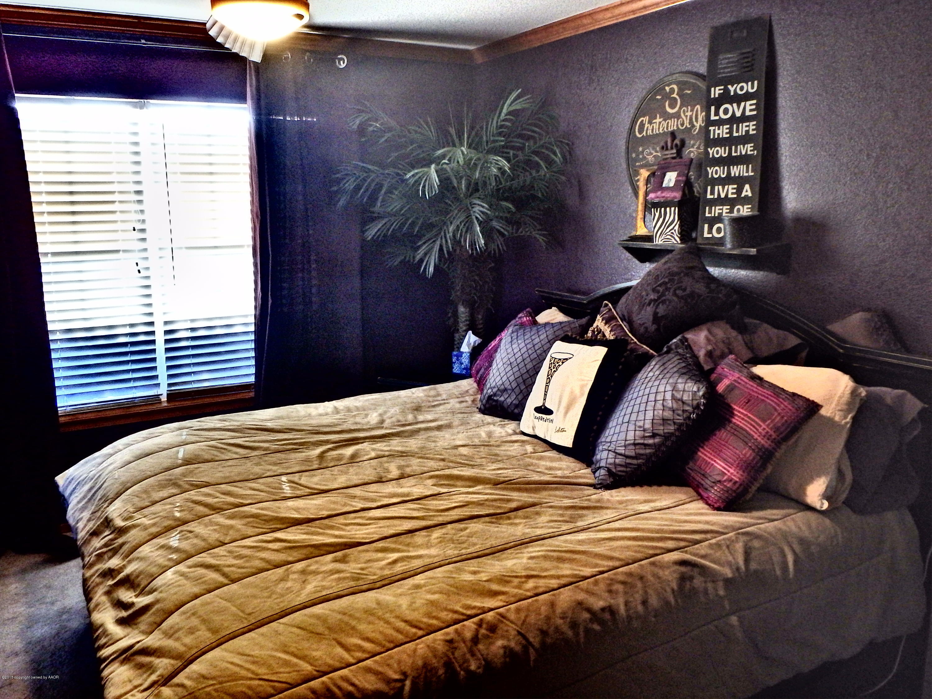 4203 Rincon Avenue Amarillo, TX 79110 - Photo 21 of 39 a bedroom with a bed and a painting on the wall