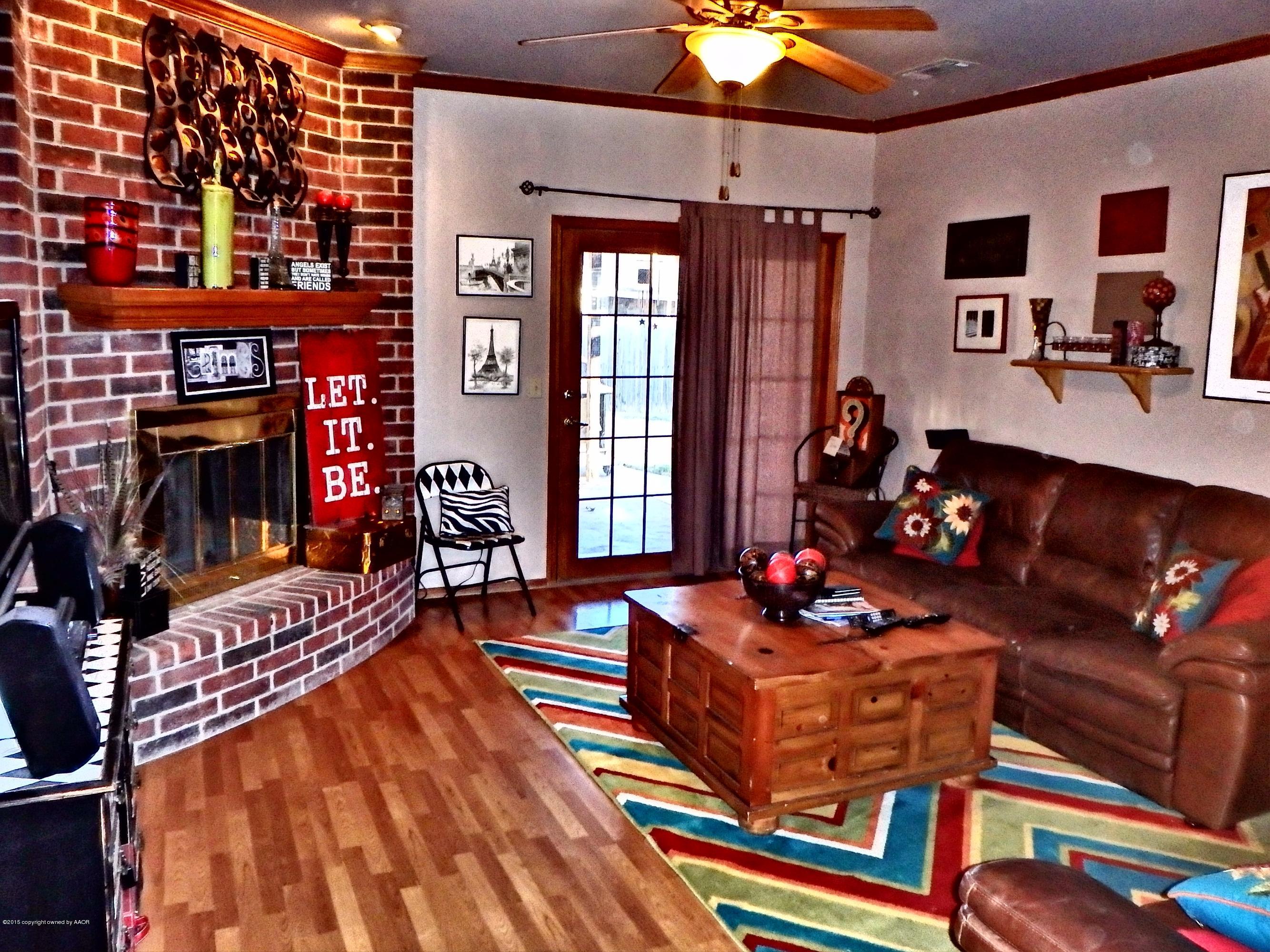 4203 Rincon Avenue Amarillo, TX 79110 - Photo 5 of 39 a living room with furniture a flat screen tv and a fireplace