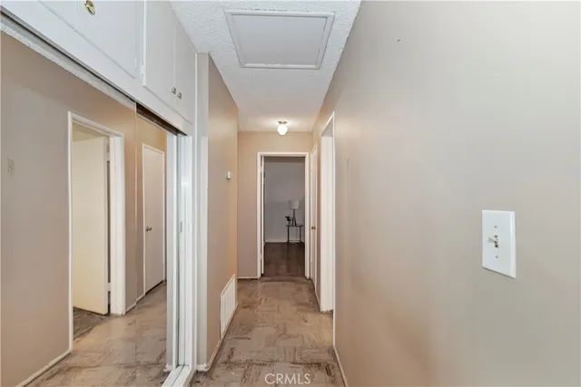 a view of a hallway with wooden shelves