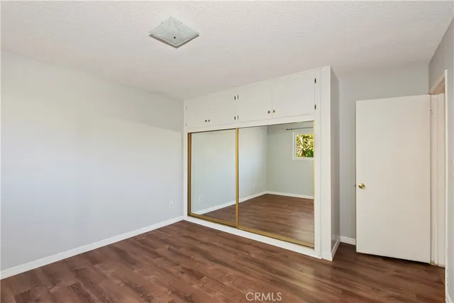 an empty room with wooden floor and closet