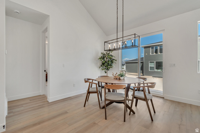 1302 1475 East, Unit 40 Payson, UT 84651 - Photo 17 of 34 Dining area featuring vaulted ceiling, light wood-type flooring, and a chandelier