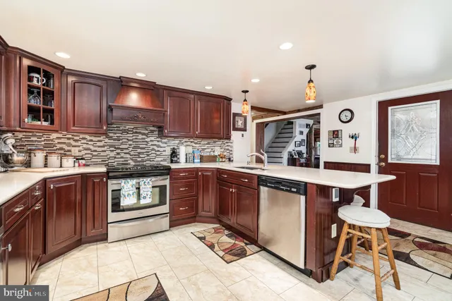a kitchen with stainless steel appliances granite countertop wooden cabinets and a stove top oven