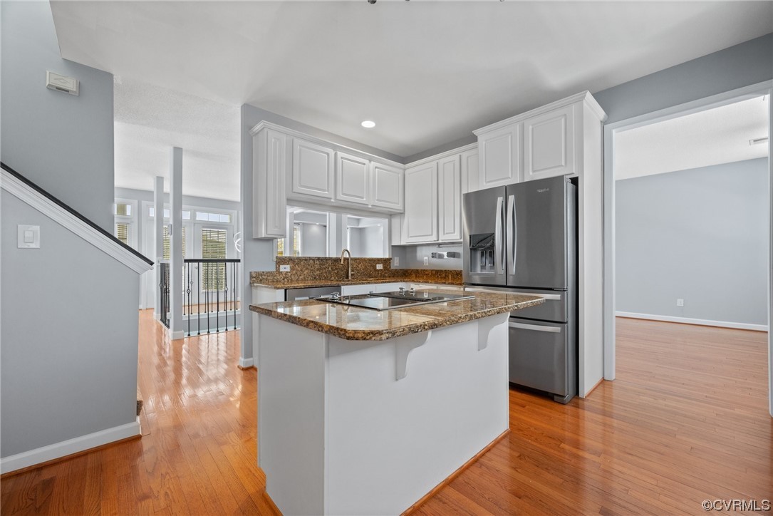15 Brough Lane Hampton, VA 23669 - Photo 30 of 43 a kitchen with kitchen island a sink stove a refrigerator and white cabinets with wooden floor