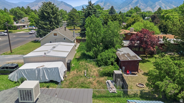 395 North 400 West Logan, UT 84321 - Photo 44 of 48 Expansive property featuring multiple structures, including a long detached garage with a metal roof, and a separate red-sided outbuilding