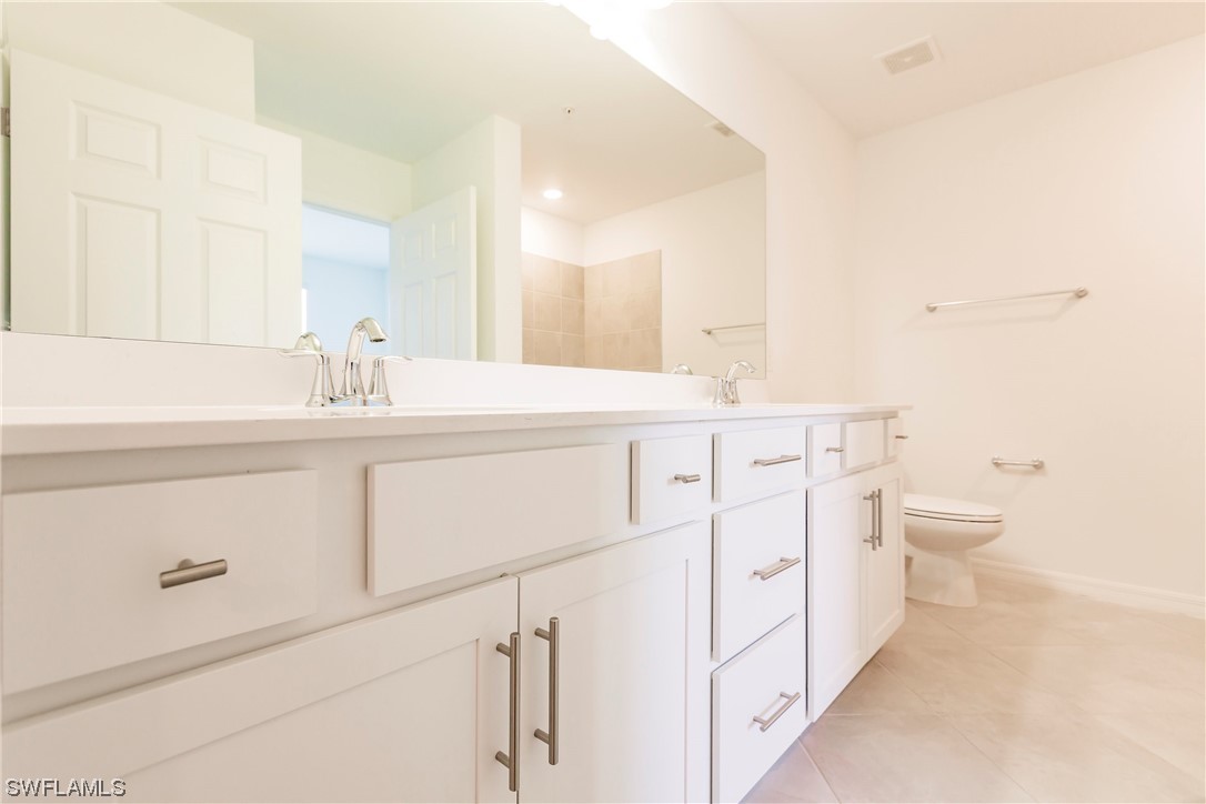 43997 Boardwalk Loop, Unit 1818 Punta Gorda, FL 33982 - Photo 14 of 40 a bathroom with a toilet sink and mirror
