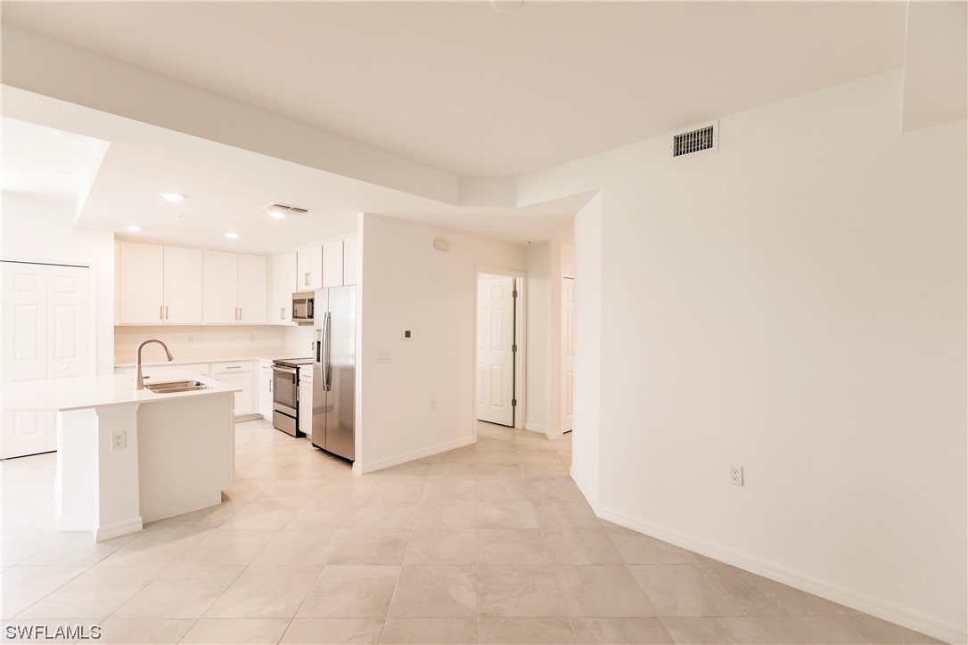 43997 Boardwalk Loop, Unit 1818 Punta Gorda, FL 33982 - Photo 26 of 40 a view of a kitchen with white cabinets and a refrigerator