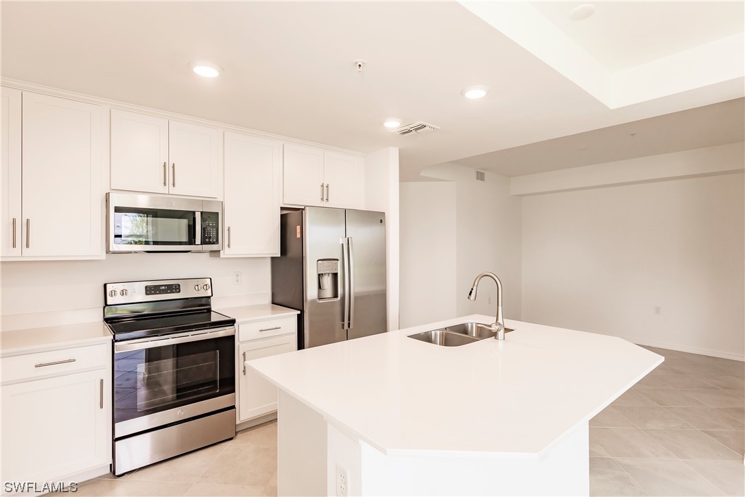 43997 Boardwalk Loop, Unit 1818 Punta Gorda, FL 33982 - Photo 5 of 40 a kitchen with stainless steel appliances a stove a sink and a refrigerator
