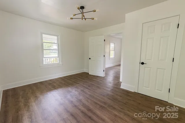 an empty room with wooden floor and ceiling fan
