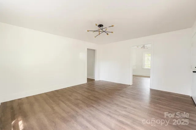 a view of empty room with wooden floor and ceiling fan