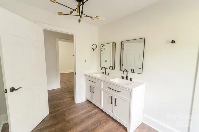 a spacious bathroom with a double vanity sink a mirror and a shower