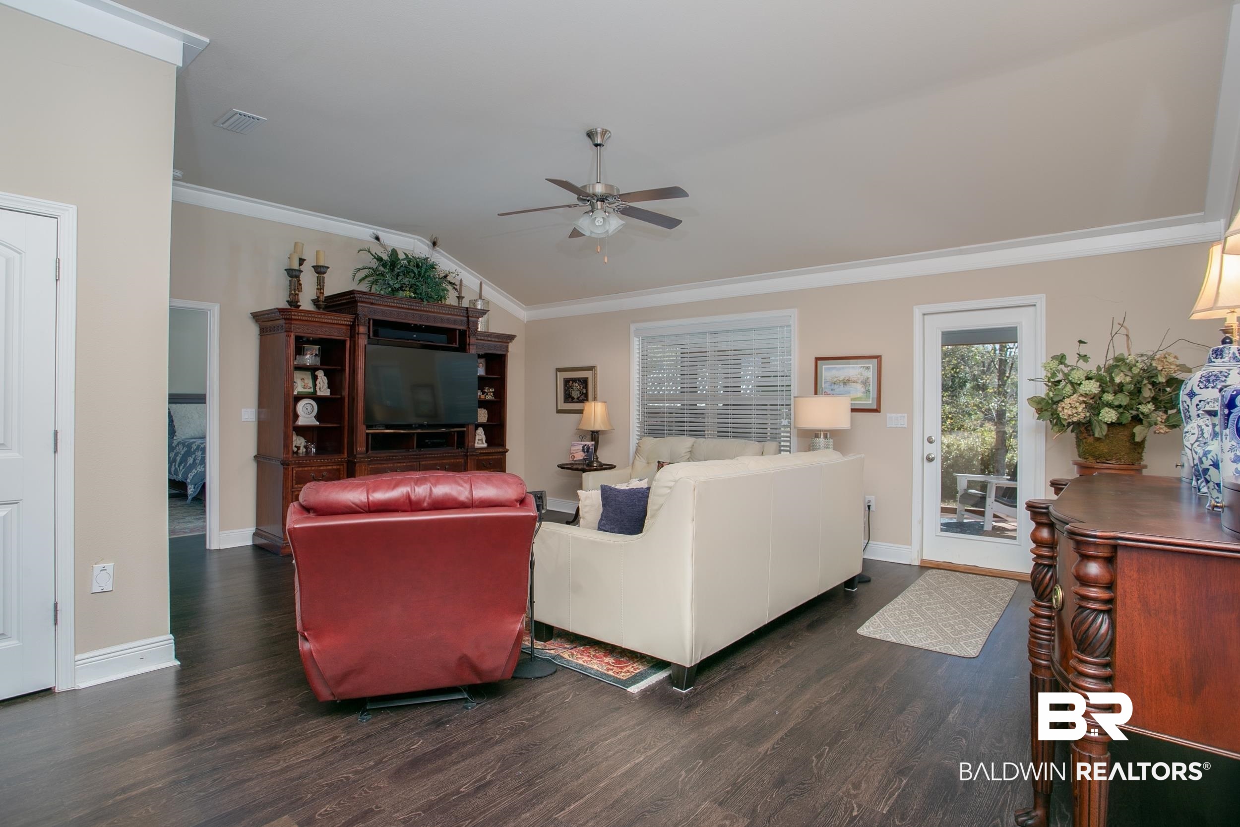 13154 Vincent Court Foley, AL 36535 - Photo 12 of 41 Living room with crown molding, dark wood-style floors, lofted ceiling, visible vents, and ceiling fan