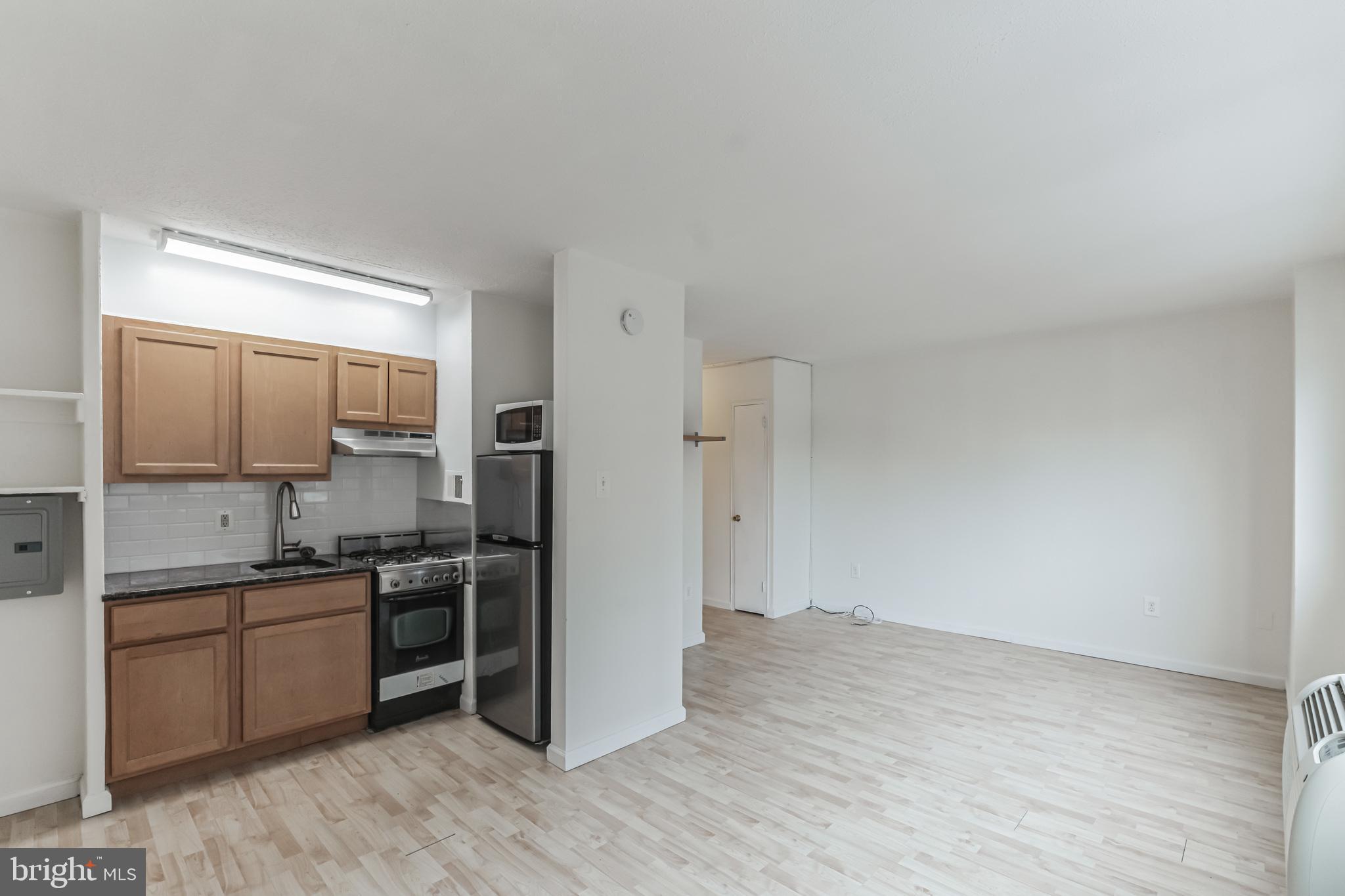 2101 Chestnut Street, Unit 1102 Philadelphia, PA 19103 - Photo 11 of 17 a view of a kitchen with a sink wooden cabinets and stainless steel appliances
