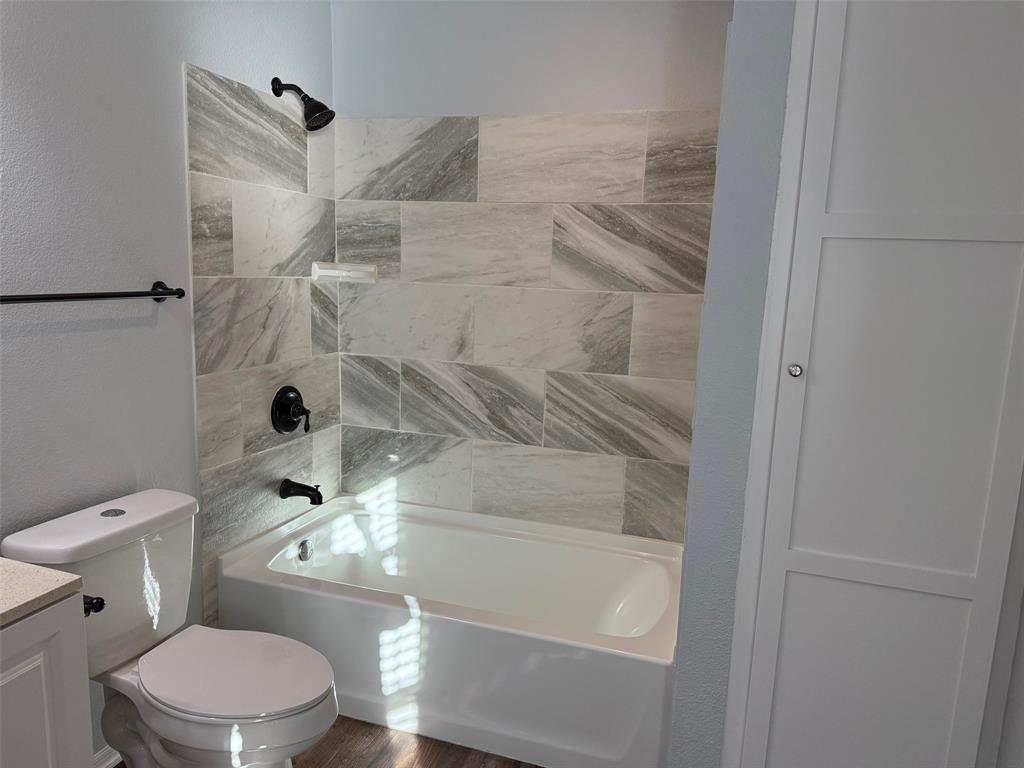 1826 North Woods Street Sherman, TX 75092 - Photo 12 of 29 a white toilet sitting next to a bath tub