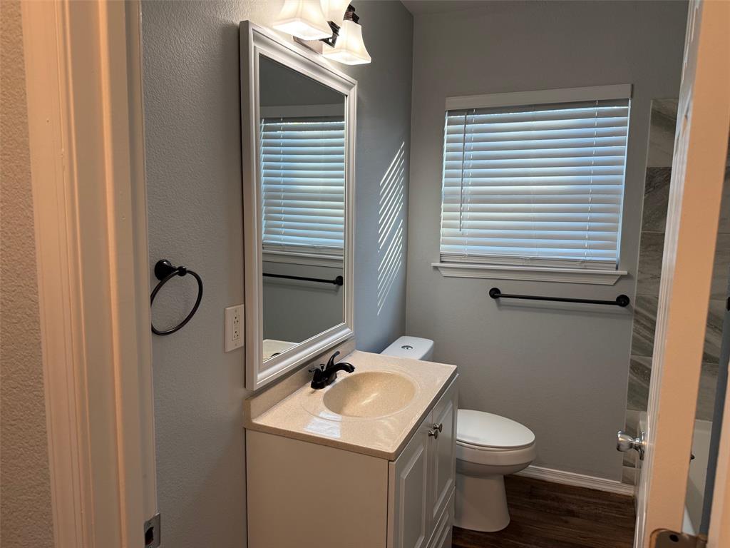 1826 North Woods Street Sherman, TX 75092 - Photo 19 of 29 a bathroom with a toilet sink and mirror