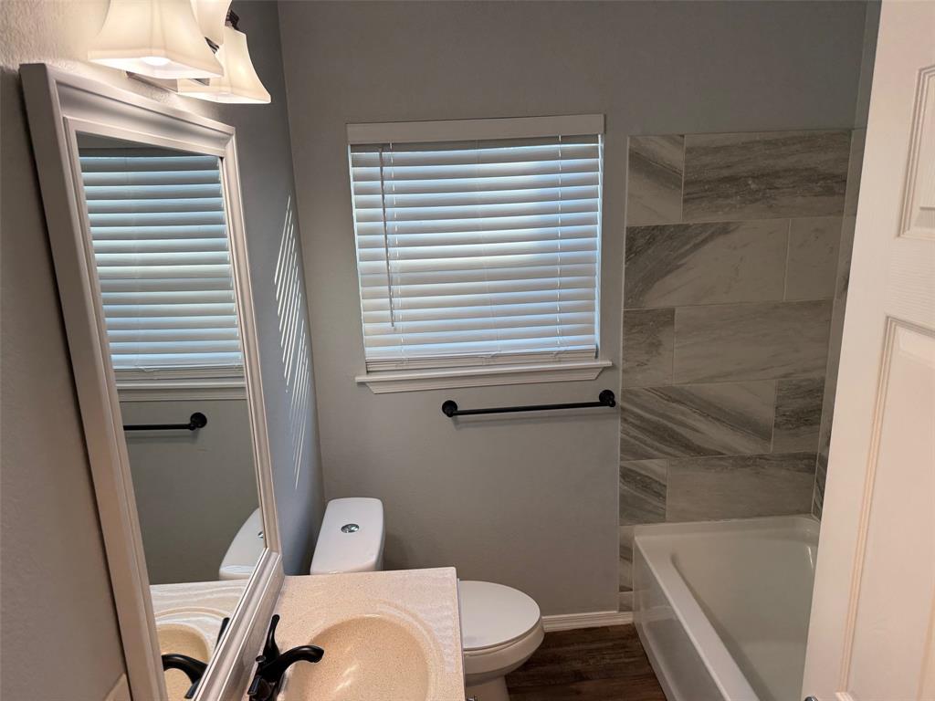 1826 North Woods Street Sherman, TX 75092 - Photo 20 of 29 a white toilet sitting next to a bath tub