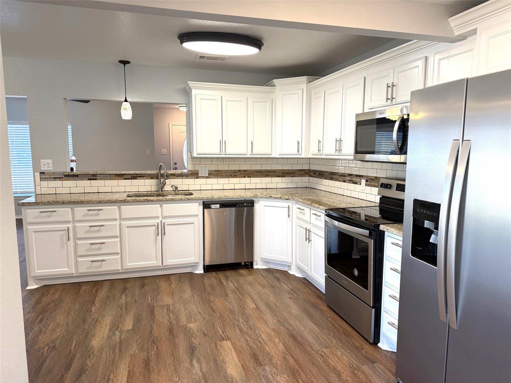 1826 North Woods Street Sherman, TX 75092 - Photo 3 of 29 a kitchen with stainless steel appliances granite countertop a stove a sink and a refrigerator