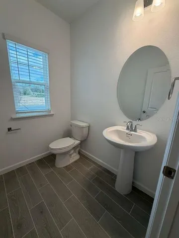 a bathroom with a sink toilet and a mirror