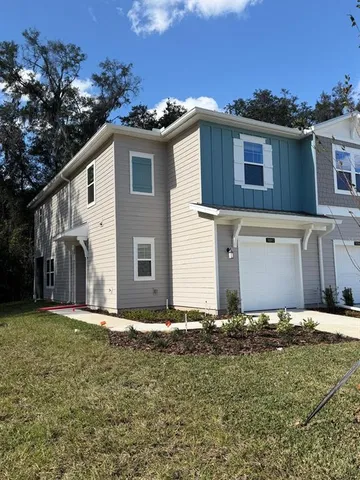 a view of a house with yard and trees
