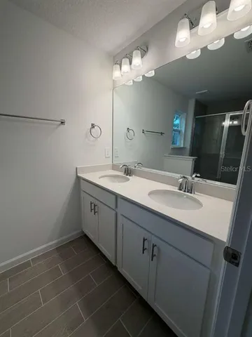 a bathroom with a double vanity sink and a mirror