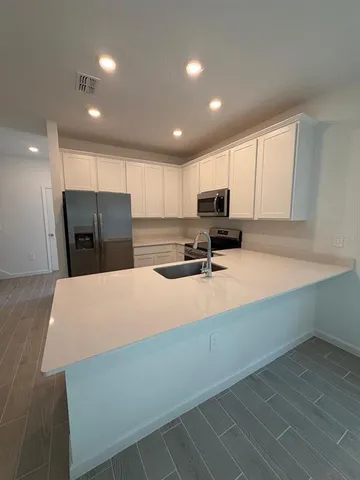 a kitchen with stainless steel appliances a refrigerator sink microwave and cabinets