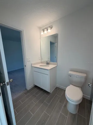 a bathroom with a sink mirror vanity and toilet