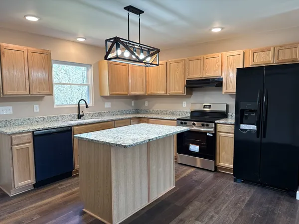a kitchen with stainless steel appliances granite countertop a sink stove and refrigerator