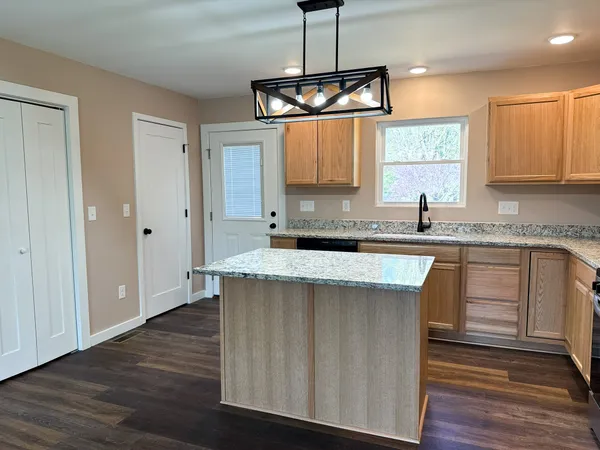 a kitchen with granite countertop a sink cabinets and window