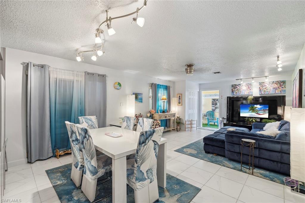 126 Harrison Road, Unit M3 Naples, FL 34112 - Photo 12 of 48 Dining area with a textured ceiling and rail lighting