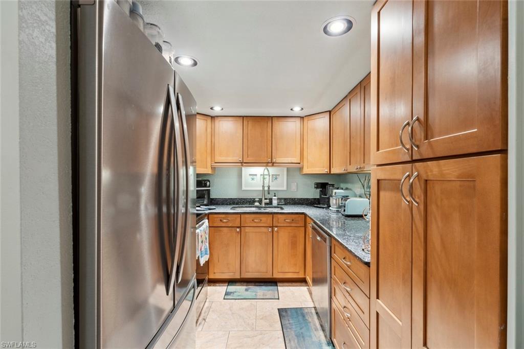 126 Harrison Road, Unit M3 Naples, FL 34112 - Photo 13 of 48 Kitchen with a sink, dark stone counters, recessed lighting, and stainless steel appliances