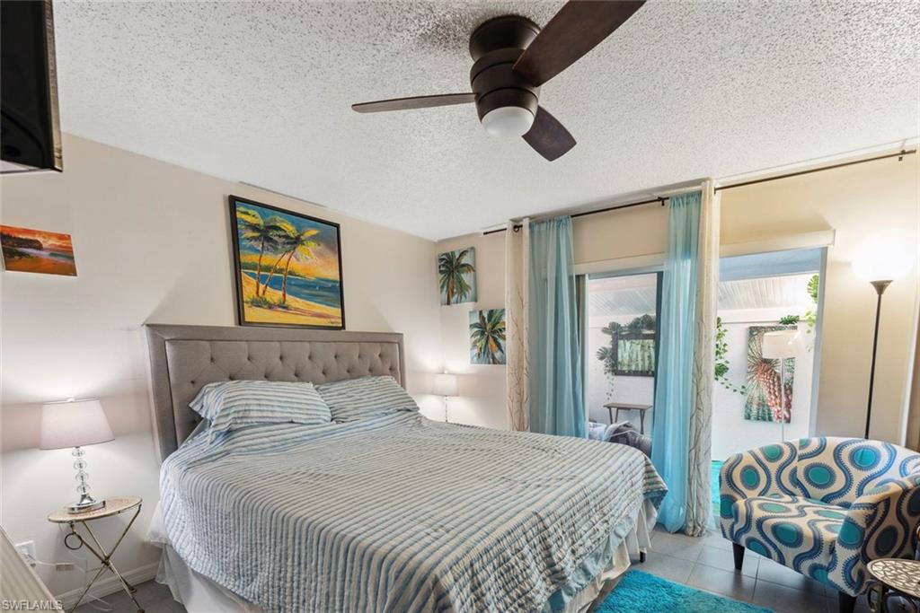 126 Harrison Road, Unit M3 Naples, FL 34112 - Photo 23 of 48 Bedroom with tile patterned floors, a textured ceiling, ceiling fan, and access to exterior