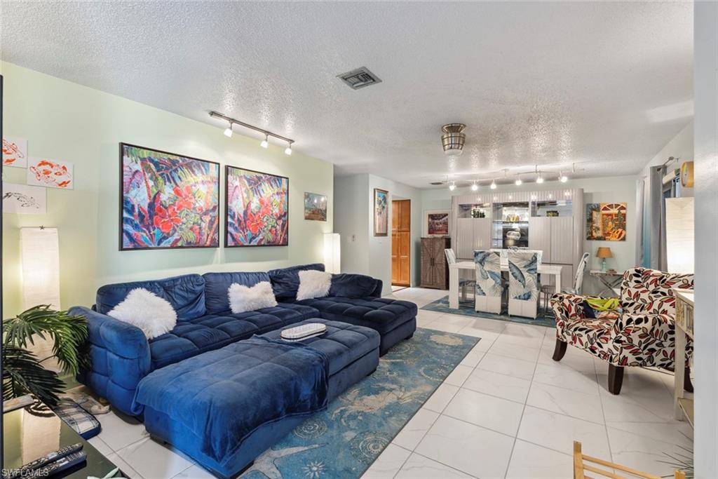 126 Harrison Road, Unit M3 Naples, FL 34112 - Photo 3 of 48 Living room featuring track lighting, visible vents, and a textured ceiling