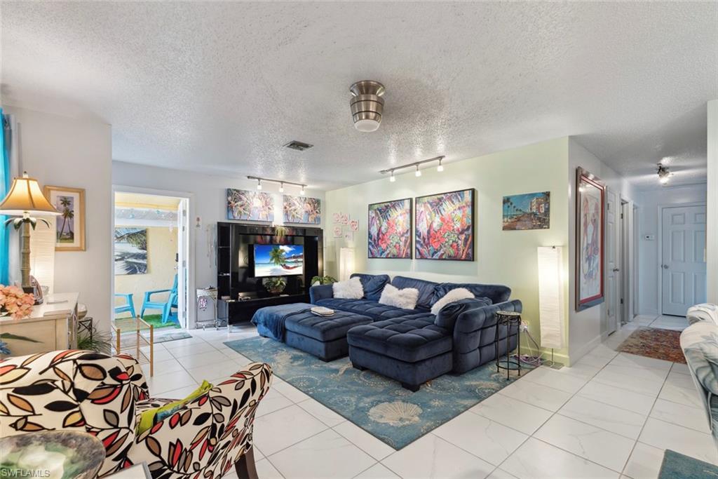 126 Harrison Road, Unit M3 Naples, FL 34112 - Photo 7 of 48 Living area with visible vents, rail lighting, and a textured ceiling