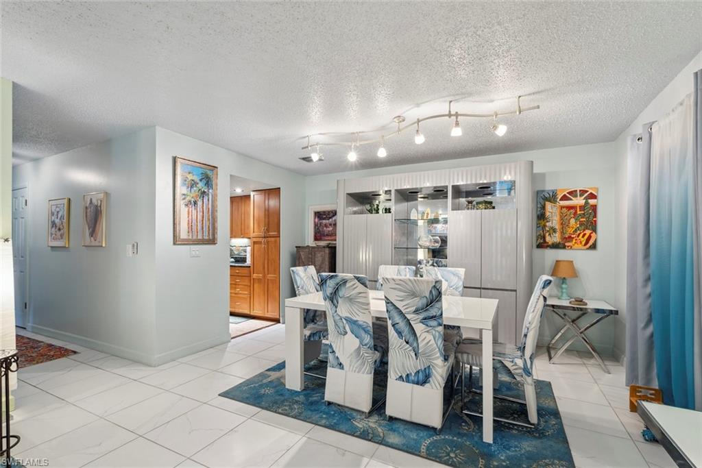 126 Harrison Road, Unit M3 Naples, FL 34112 - Photo 9 of 48 Dining room featuring baseboards and a textured ceiling