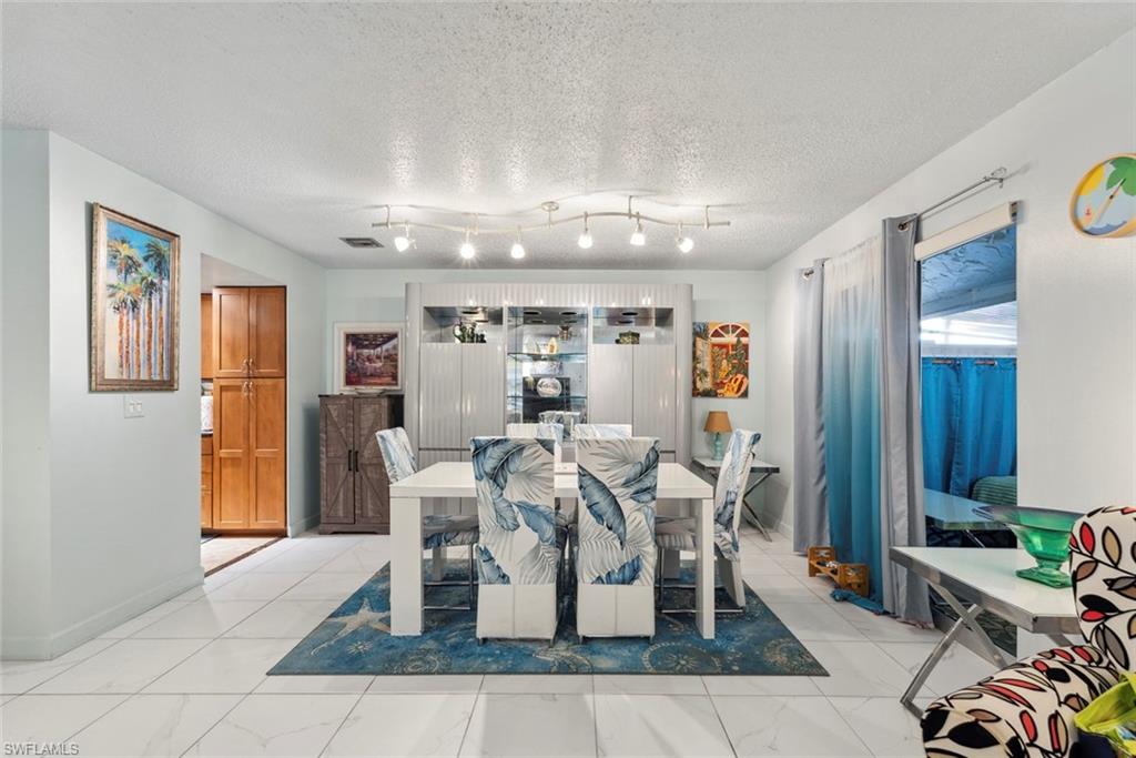 126 Harrison Road, Unit M3 Naples, FL 34112 - Photo 10 of 48 Dining room featuring visible vents, baseboards, and a textured ceiling