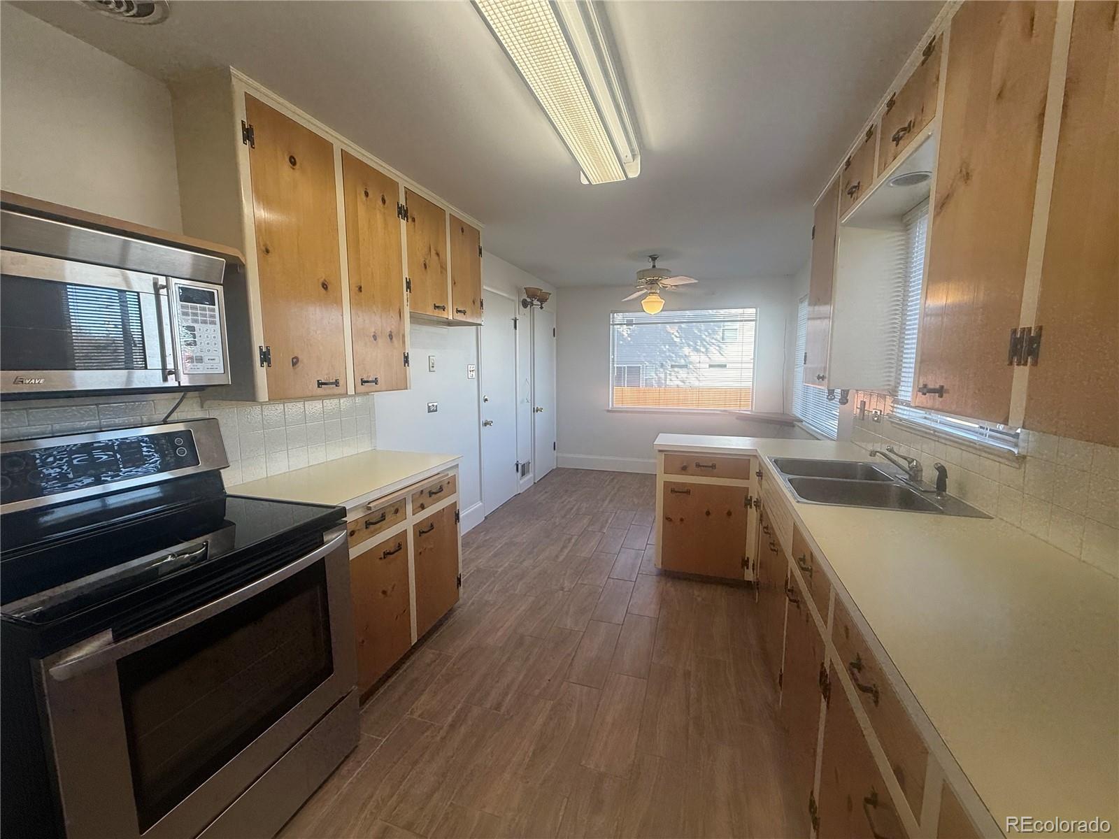 2355 Ames Street Edgewater, CO 80214 - Photo 22 of 29 a kitchen with a stove a sink and a microwave