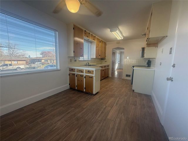 a kitchen with stove and wooden floor
