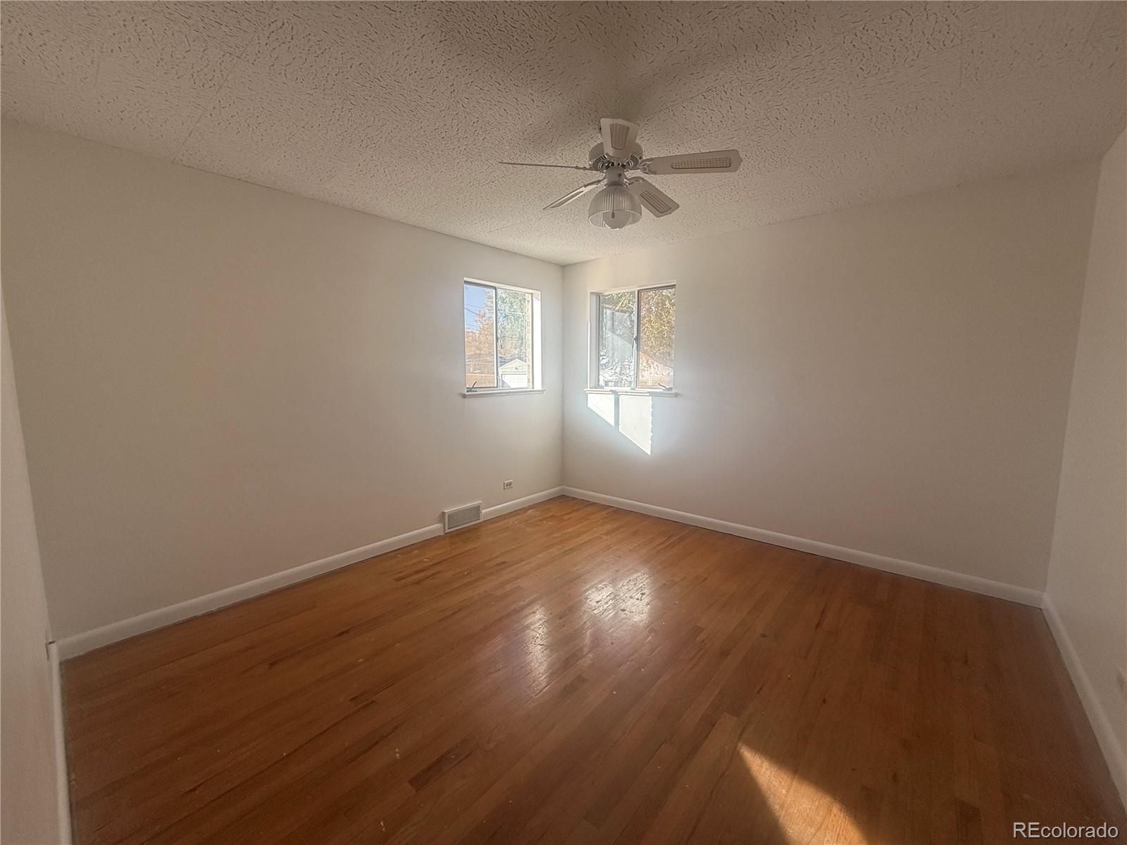 2355 Ames Street Edgewater, CO 80214 - Photo 7 of 29 an empty room with wooden floor fan and windows