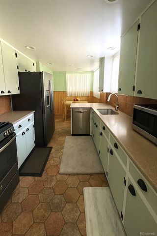 a large kitchen with a stove a sink dishwasher a refrigerator and a oven