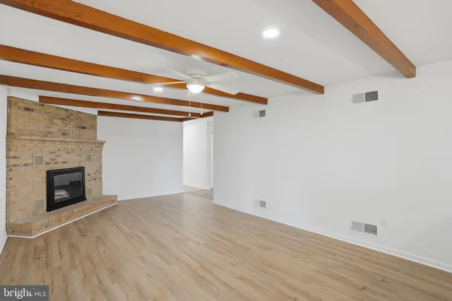 a view of a livingroom with wooden floor and a fireplace